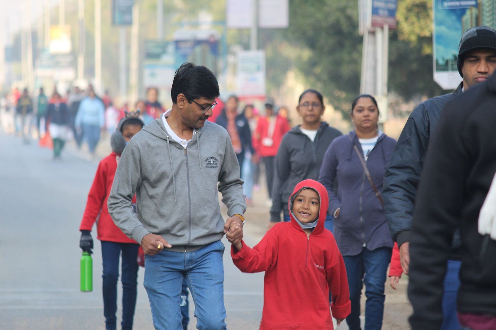 Father and Child Holding Hands During Community Morning Walk Event